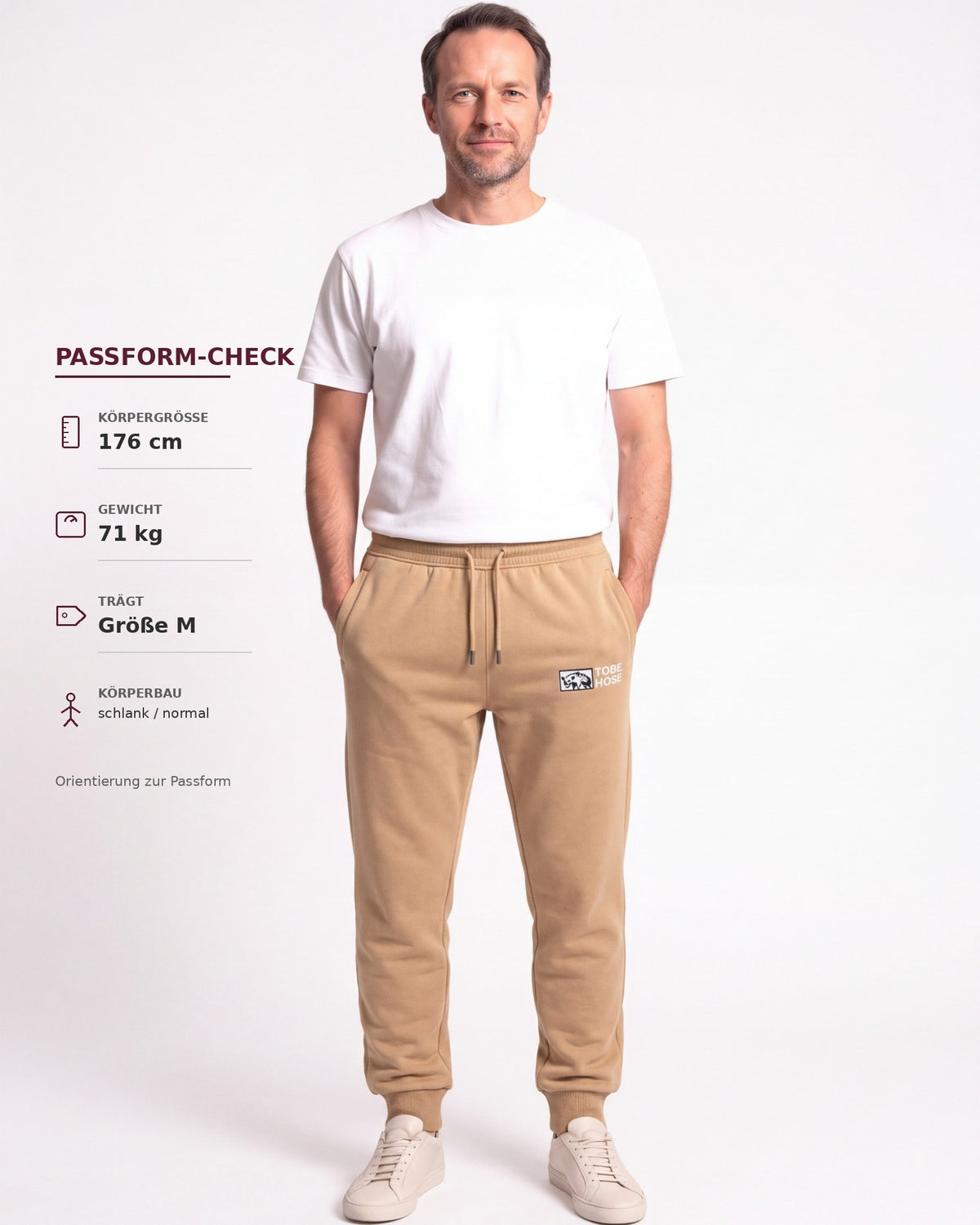 Tobe Hose Studio Herren-Jogginghose in Beige mit Hyänen-Logo-Stickerei, getragen von einem Model zur Passform-Analyse