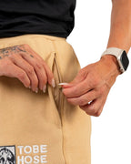 Tobe Hose Studio Damen Jogginghose in Beige mit Reißverschlusstasche und gesticktem Hyänen-Logo