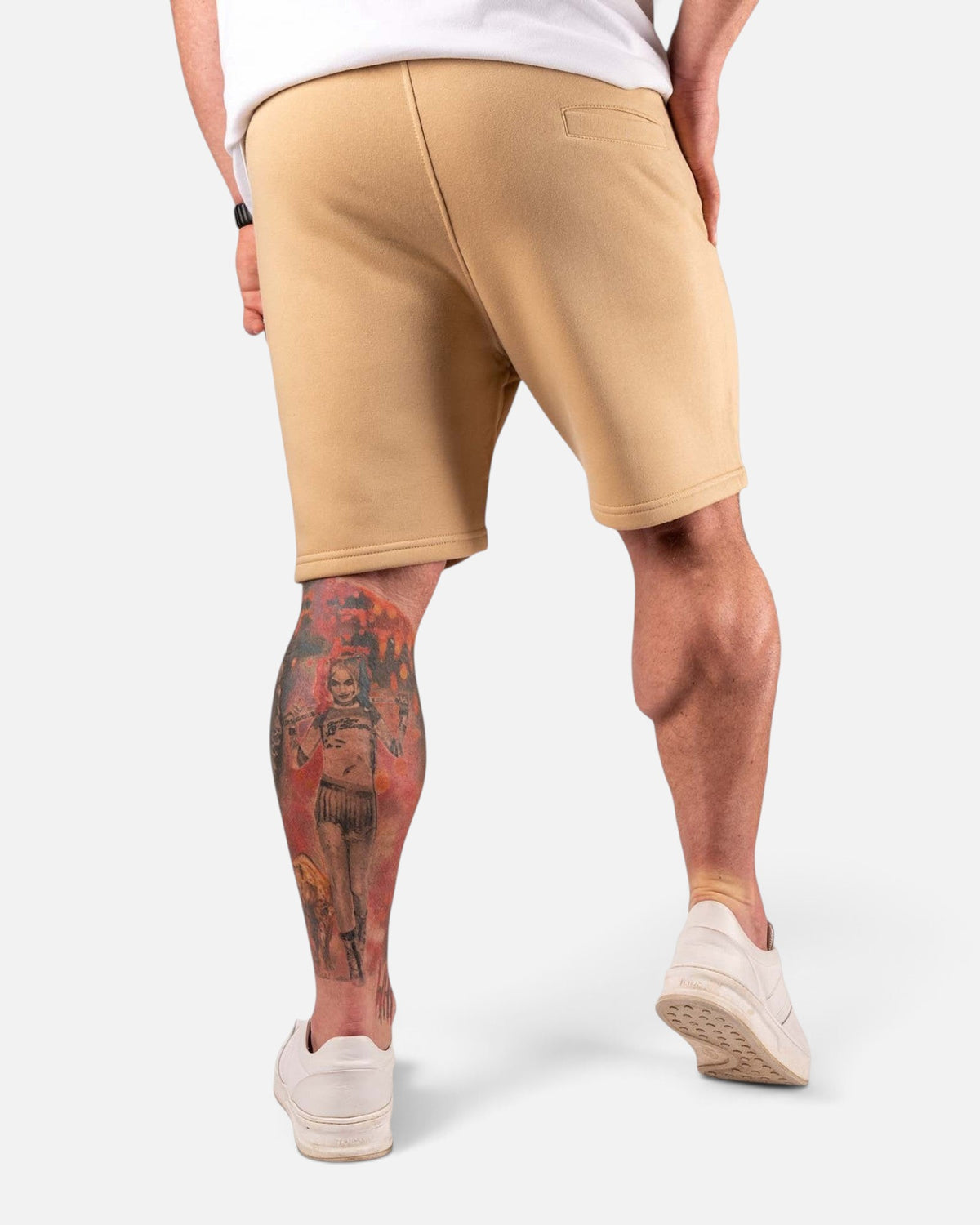 Tobe Hose Studio Shorts in Beige aus Baumwolle, Rückansicht an einem Model mit tätowiertem Bein