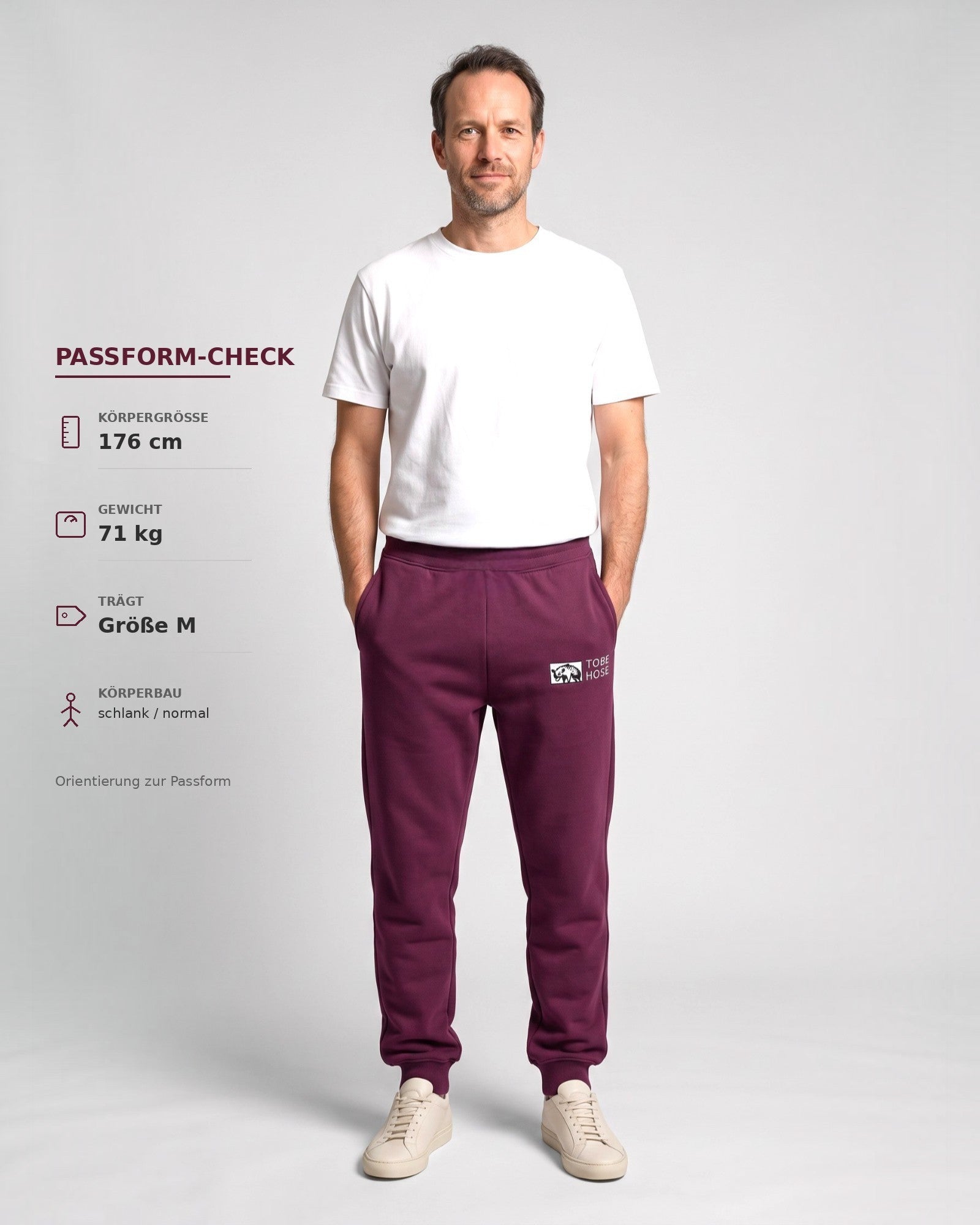 Tobe Hose Studio Herrenhose in Pflaume mit Hyänen-Logo, elastischem Bund und Reißverschlusstaschen an einem Model