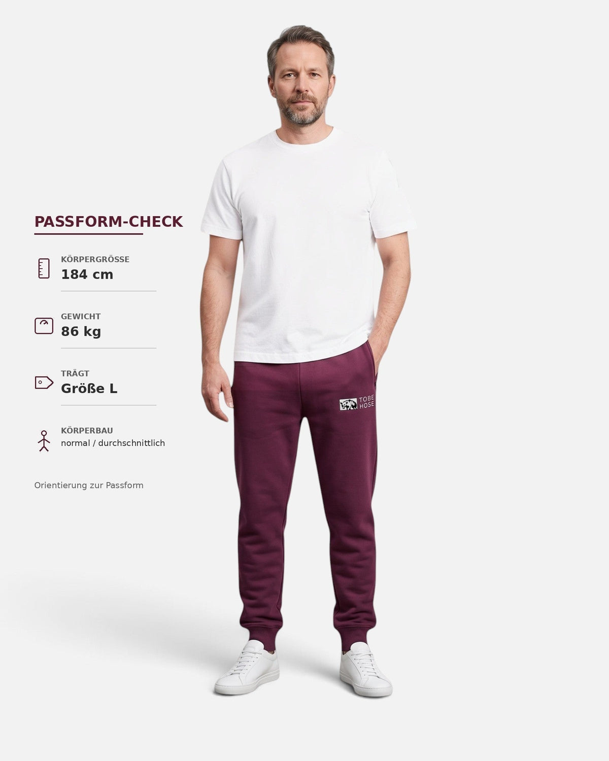 Tobe Hose Studio Herrenhose in Pflaume mit Bündchen, Reißverschlusstaschen und Hyänen-Logo, getragen von einem Model