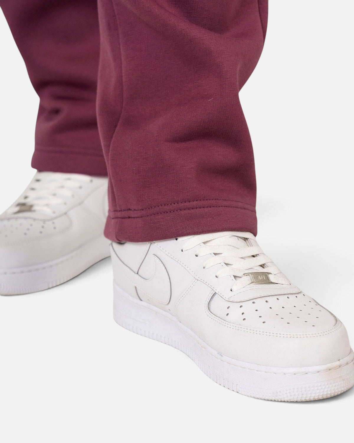 Tobe Hose Studio Herrenhose in Pflaume aus robustem Stoff mit offenem Beinabschluss kombiniert mit weißen Sneakern