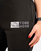 Tobe Hose Studio Damen-Jogginghose in Schwarz mit gesticktem Hyänen-Logo und seitlicher Reißverschlusstasche