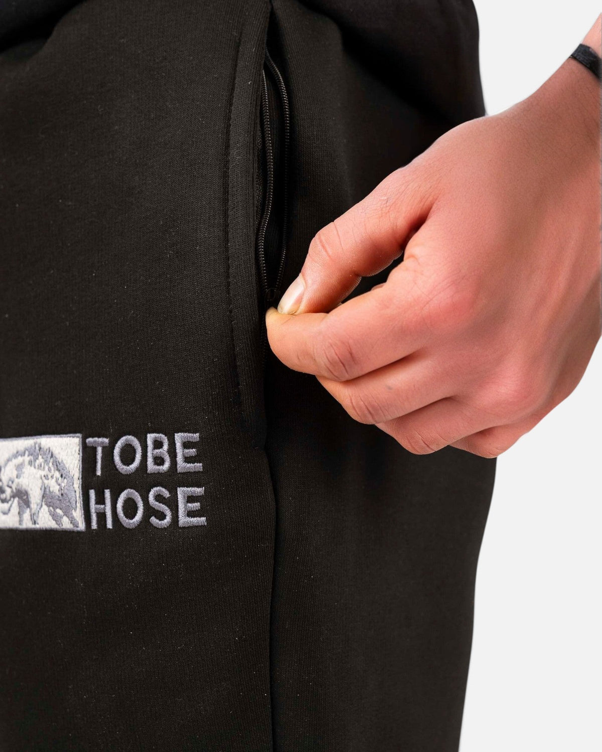 Tobe Hose Studio Herrenhose in Schwarz mit Reißverschlusstasche und gesticktem Hyänen-Logo