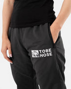 Tobe Hose Studio Damen-Hose Luft in Schwarz aus robustem Nylon mit Reißverschlusstasche und gesticktem Hyänen-Logo