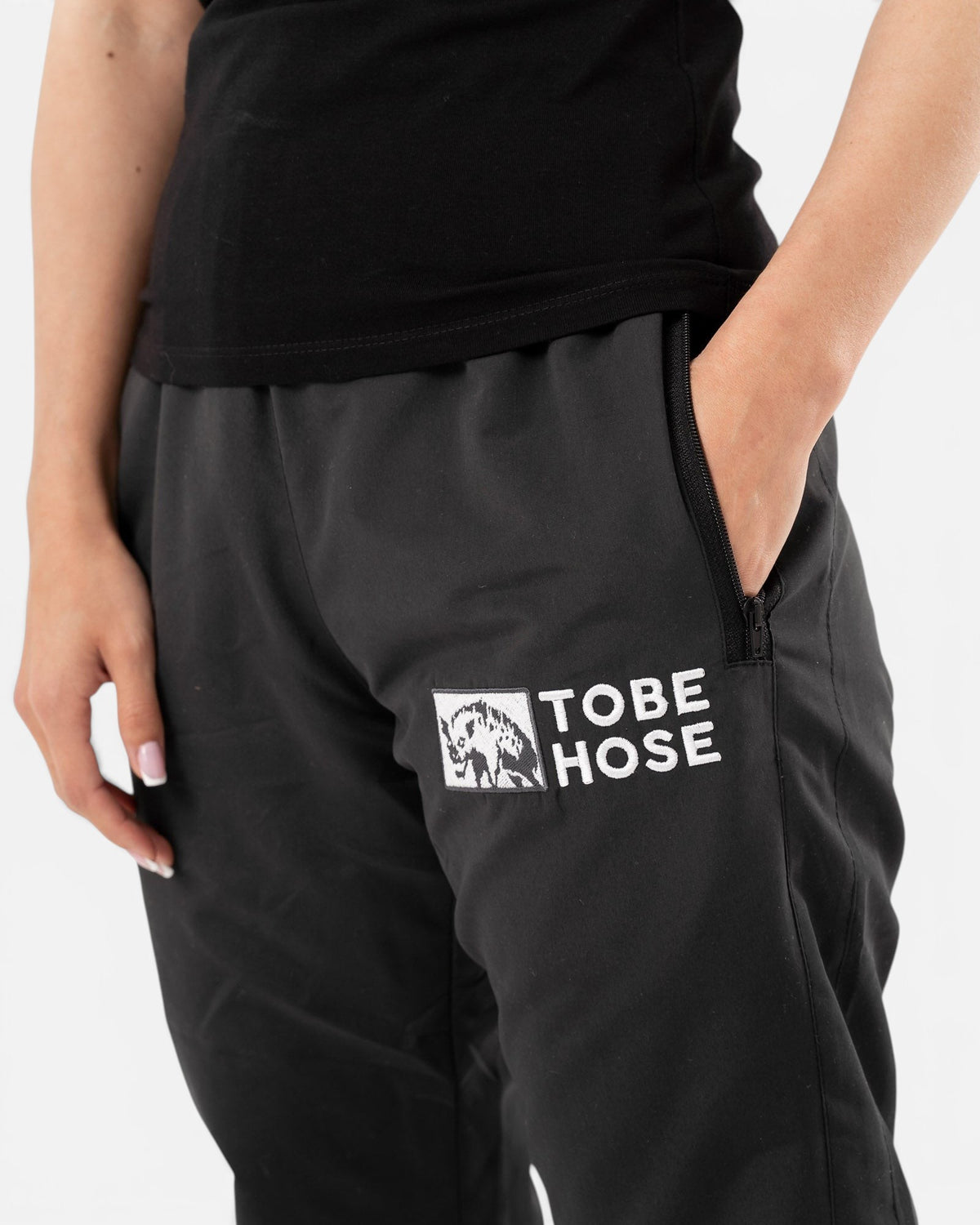 Tobe Hose Studio Damen-Hose Luft in Schwarz aus robustem Nylon mit Reißverschlusstasche und gesticktem Hyänen-Logo