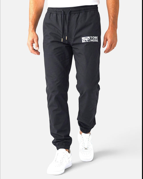 Tobe Hose Studio Herrenhose Luft in Schwarz aus robustem Nylon mit gesticktem Hyänen-Logo und Reißverschlusstaschen