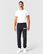 Tobe Hose Studio Luft Herrenhose in Schwarz aus robustem Nylon mit gesticktem Hyänen-Logo und Reißverschlusstaschen