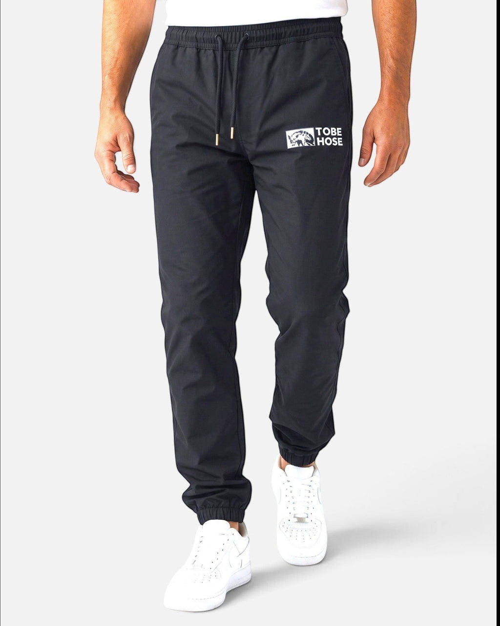 Tobe Hose Studio Herrenhose Luft in Schwarz aus robustem Nylon mit gesticktem Hyänen-Logo und Reißverschlusstaschen